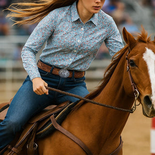 A rider showcasing the Jessicas Pride Belt Buckle with a floral shirt and denim jeans on a horse